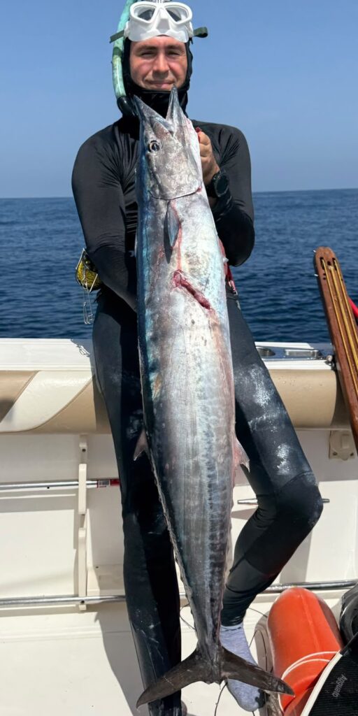 Pescador submarino con un wahoo arponeado en Cancún