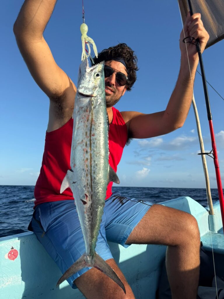 Pescador con una sierra capturada con señuelo en lancha de pesca en Cancún